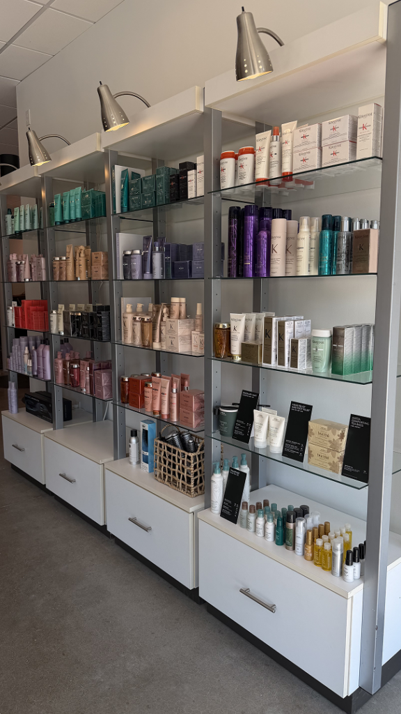Shelves display a variety of hair and beauty products in bottles and boxes, organized by type and color, in a well-lit retail store. | Salon Blonde in Columbia, TN, Spring Hill, TN, Franklin, TN